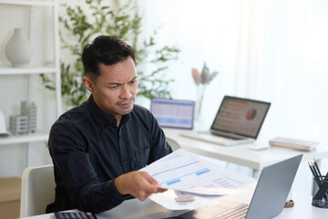 Naklejka premium Frustrated businessman dealing with work problems in a modern office.