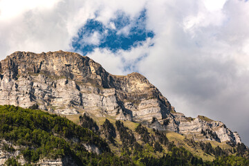 Fototapeta premium Switzerland, Swiss Alps, Canton St. Gallen, Churfirsten group, Frümsel and Hinterrugg, mountain range, summer. Cloudscape, sunlight, landscape. Hiking, tourism, travel destination, recreation.