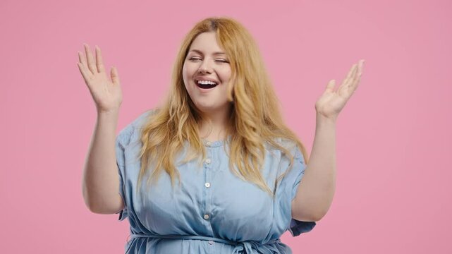Surprised plus size woman making mind blown, idea gesture on pink background