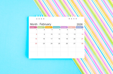 February 2026 desk calendar on blue and rainbow color background.