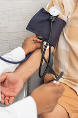 Doctor measuring blood pressure of senior patient at home