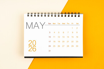 Desk calendar for May 2026 year on yellow color background, Flat lay.