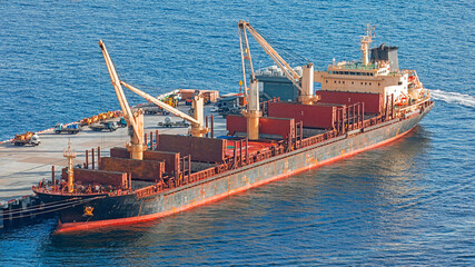 Aerial view of cargo container ship approaching port.