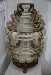 The antique lighthouse lens with Ornate brass and layered glass, a testament to maritime history.