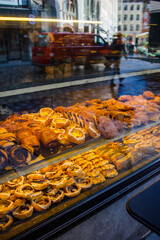 Danish pastry: many different sweet buns made in bakery through the window from the street
