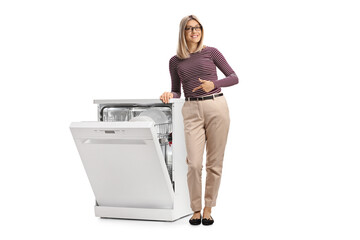 Smiling young woman pointing at a dishwasher