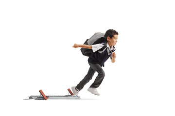 Full length profile shot of a boy in a school uniform running from start blocks
