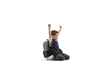 Schoolboy sitting on knees and gesturing happiness