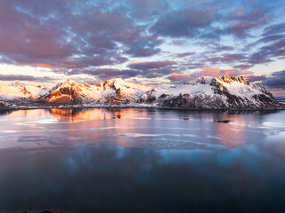 Snow-capped mountains reflecting in calm lake