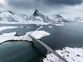 Snow-Covered Bridge Over Fjord and Mountains