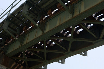 A historic stone railway bridge with metal tracks supported by massive stone pillars, stretching...