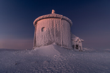 Frozen Chapel in Snowy Landscape at Dusk