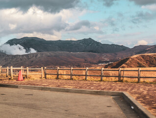 Dramatic Volcanic Terrain with Sunset Sky and Wooden Barrier in Kyushu, Japan