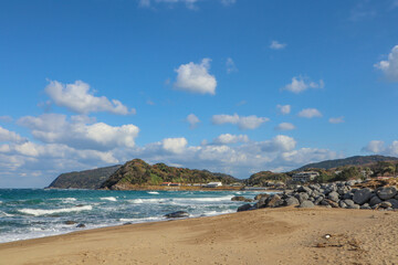 Tranquil Rocky Shoreline Under Blue Sky and Clouds