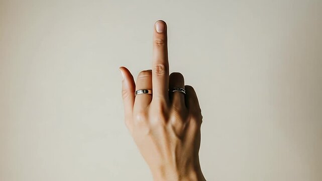 Close-up of a hand making an offensive gesture with middle finger extended in anger