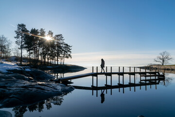 Woman walking on dock in Oslo winter landscape