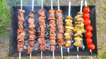 Beef shashlik grilling over open coals on mangal. Juicy meat, mushrooms, cherry tomatoes with crispy, golden crust skewered on metal sticks. Atmosphere rustic outdoor cooking scene, smoke rises