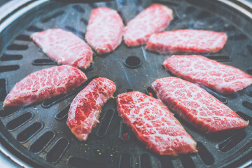 grilling meat on a charcoal grill in a korean restaurant