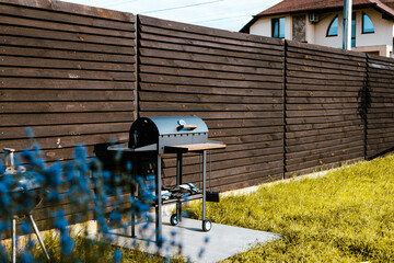 A barbecue grill and patio are ready for outdoor cooking in a backyard. A BBQ grill in front of a...