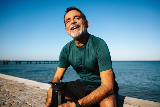 Smiling man enjoying outdoors by a scenic waterfront setting