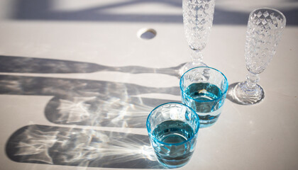 still life with vintage water and champagne glasses in the sun