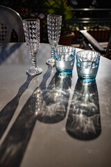 still life with vintage water and champagne glasses in the sun