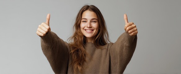 The smiling woman giving thumbs up in a cozy sweater.
