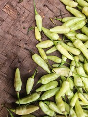 Fresh, pale green chilies on a woven mat.