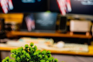 Modern home office desk setup with American Independence Day theme, including monitors displaying US flag wallpaper, bonsai tree, microphone, and warm cozy lighting ambiance.