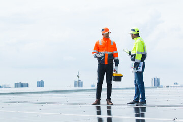Electrical engineers are inspecting and installing a solar panels on the building rooftop.