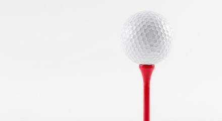 A white golf ball sits atop a bright red tee on a clean backdrop