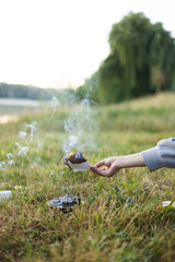 Woman burning letter with resentment outdoors as emotional release ritual.