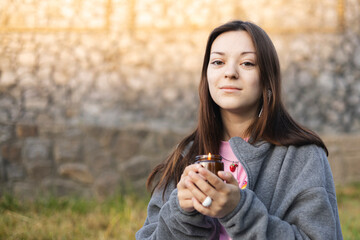 Teen girl holding candle outdoors in nature, peaceful mood and natural light.