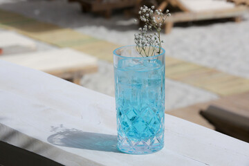 Blue Lagoon Cocktail, Angelo azzurro cocktail in tall glass on the table in the beach bar	
