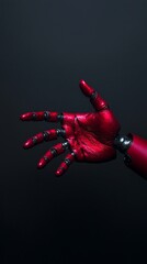 A close-up of a red robotic hand with detailed joints, partially open against a dark background.