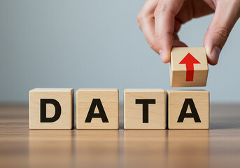 Naklejka premium Data analysis and management concept with wooden blocks showing data and an upward arrow on top block