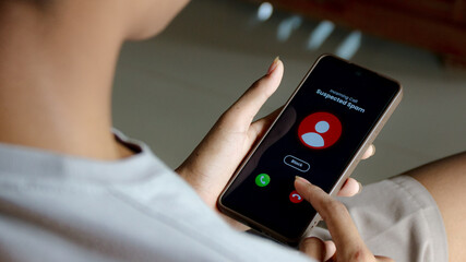 Person Blocking Suspected Spam Call on Smartphone