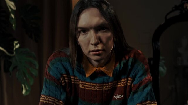 young guy with long hair stares at the camera