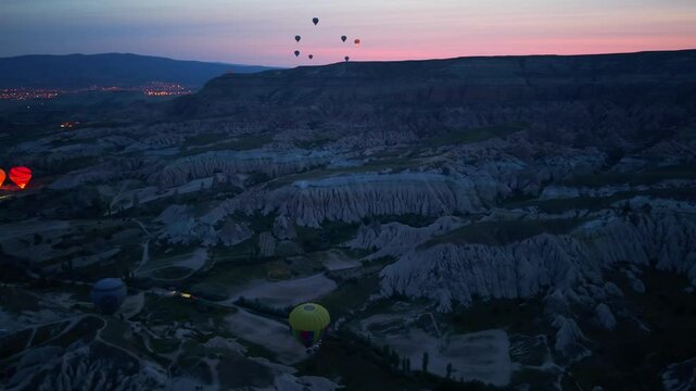 Drone footage of colorful balloons over Cappadocia landscape, Turkey