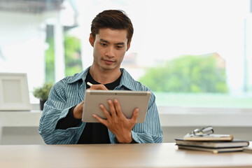 A Focused Designer Working on Digital Art with Stylus, Digital Artist Creating on Tablet