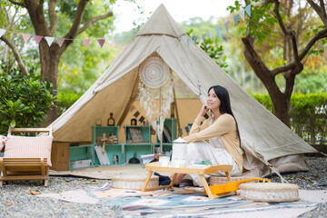 Woman go camping and sitting outside her campsite tent