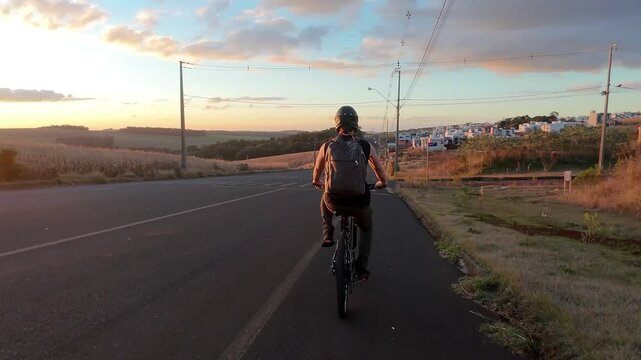 homem ciclista anda de bicicleta no p&ocirc;r do sol 