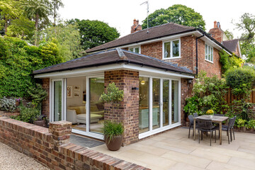 Photo of modern brick house with glass extension and patio