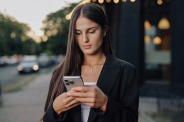 Business woman using smartphone at city street
