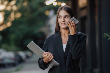 Elegant business woman send a voice message in the city