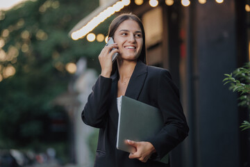 Elegant business woman talking by smartphone in the city