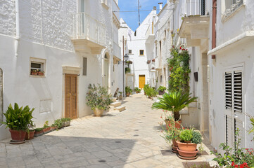 Narrow alley with typical old houses with white walls in the old town of Locorotondo, Apuglia...