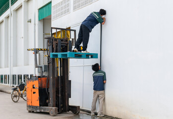 Two technicians are repairing a sliding door at the warehouse.