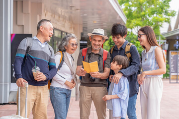three generations family as the tourists having backpacks and suitcase standing at tourist center,holding brochure looking for attractive  places to visit,family outing on summer vacation trip