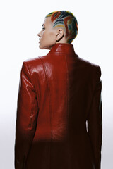 Woman with colorful patterned shaved hair wearing a red leather jacket, seen from the back against...